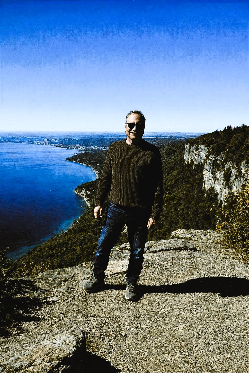 Paul Davidson standing outdoors overlooking a lake and mountains